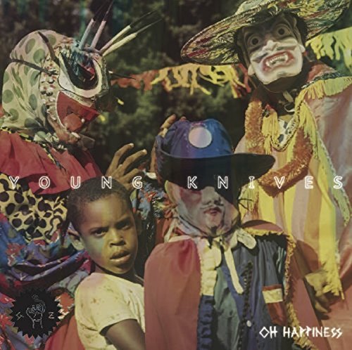 "Album cover with four people in colorful costumes, masks, and hats, outdoors."