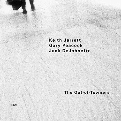 "Album cover with grey, grainy background, black text, and partial image of legs."