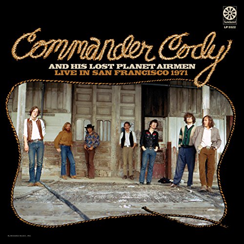 Vinyl record cover with six men standing in front of a wooden building.