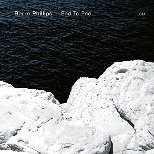 "Album cover featuring white rocks against dark water with artist and title in white text."