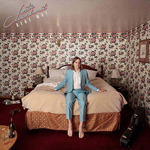 Dent May album cover: man in suit seated on a hotel bed.