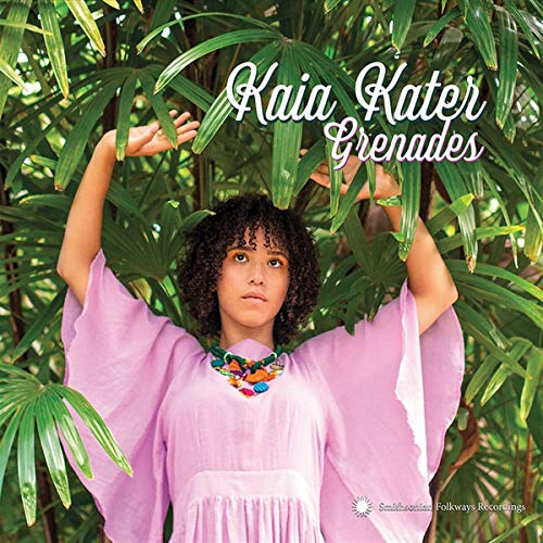 Woman in pink dress and colorful necklace standing among green leaves with album title "Grenades" above.