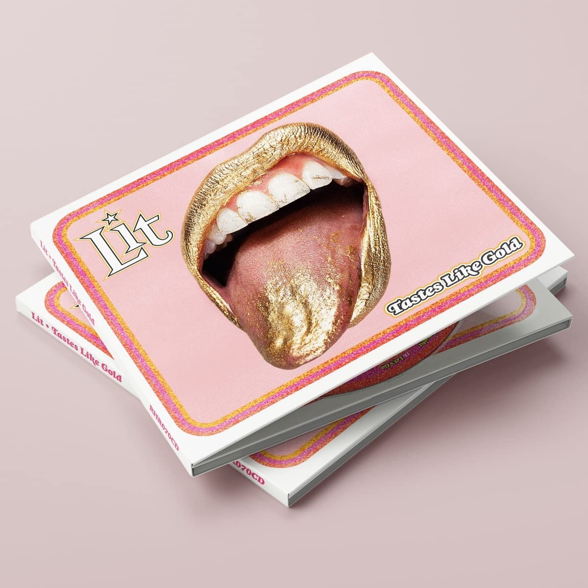 "Stack of CDs with pink cover featuring a mouth with gold-painted tongue and lips."