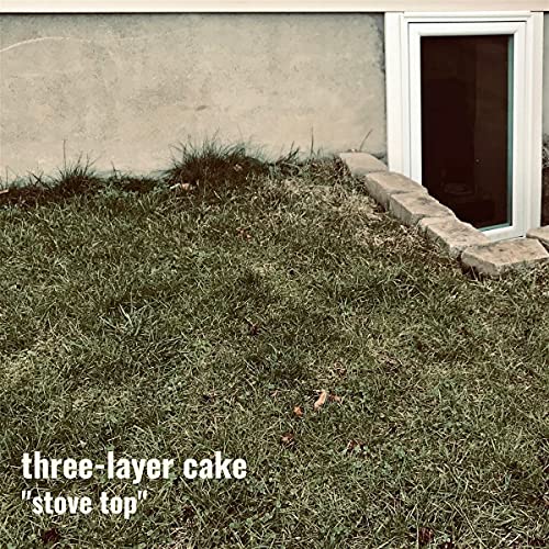 Vinyl record cover with text “three-layer cake ‘stove top’” on grass.