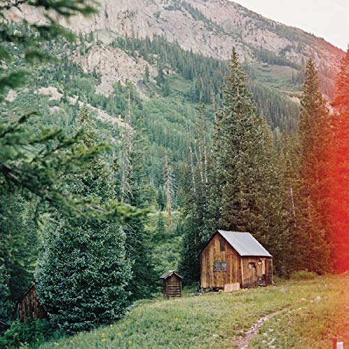 A vinyl record sleeve featuring a serene image of a wooden cabin.