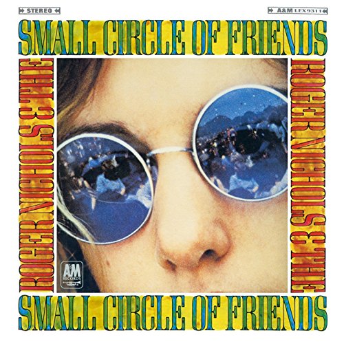 Album cover with a person wearing sunglasses, reflecting a scenic landscape and people.