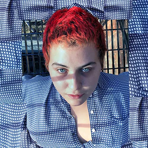 Lily Konigsberg with short red hair, looking directly at the viewer.