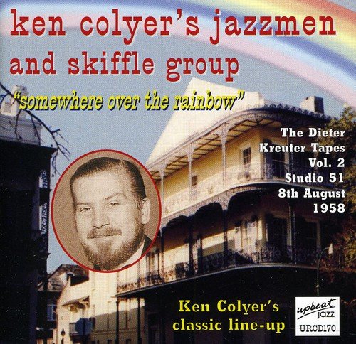 "CD cover with a building, rainbow, and portrait of a man."