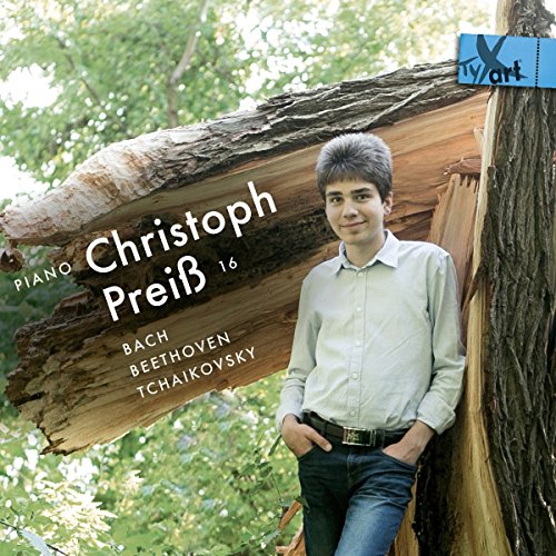 A young man leans against a tree trunk with a CD cover overlay.