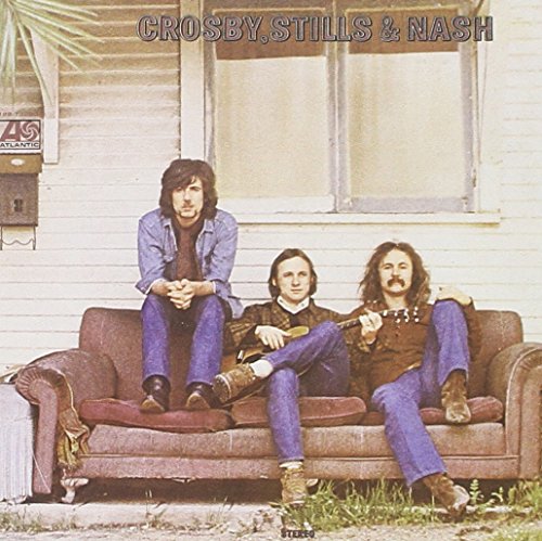 "Album cover featuring three men sitting on a couch outside a white house."