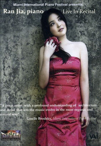 The image is a DVD cover featuring a woman in a red dress. #### Alt Text Woman in red dress holding a flower, against a gray wall.