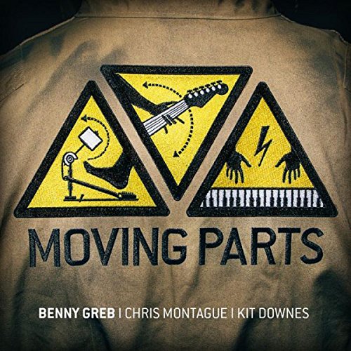 The image shows a tan jacket with a warning sign design and text. "Tan jacket with yellow warning signs and 'Moving Parts' text, featuring musician names."