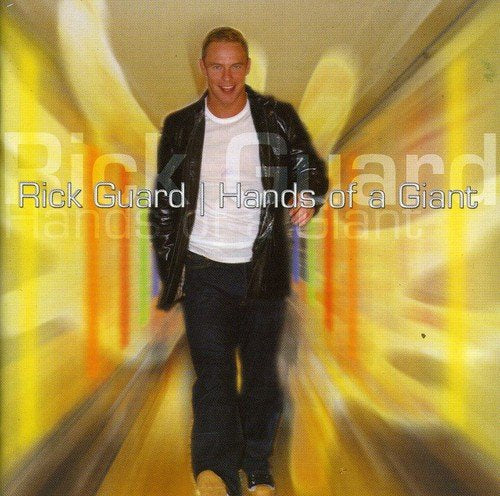 CD cover featuring Rick Guard walking towards the viewer in yellow light.