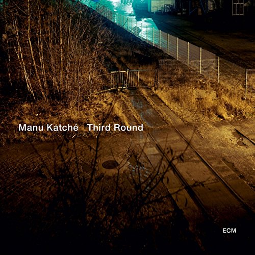 "Album cover with a dimly lit train track scene and white text overlay."