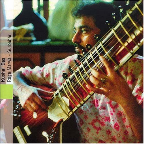 "Man playing a sitar, wearing a white shirt with red floral pattern."