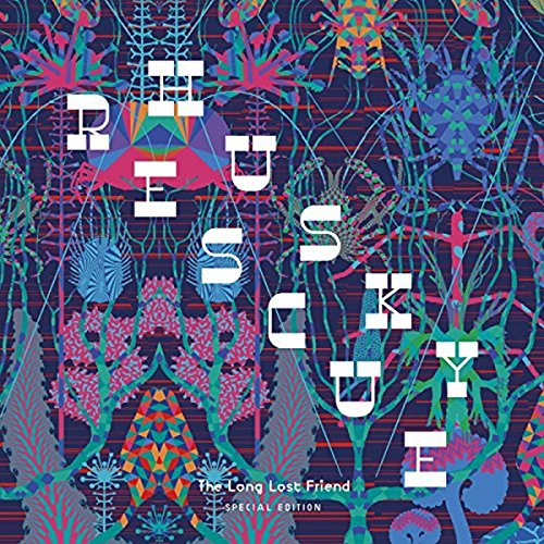 Album cover with a woman working at a cluttered wooden table in a studio.