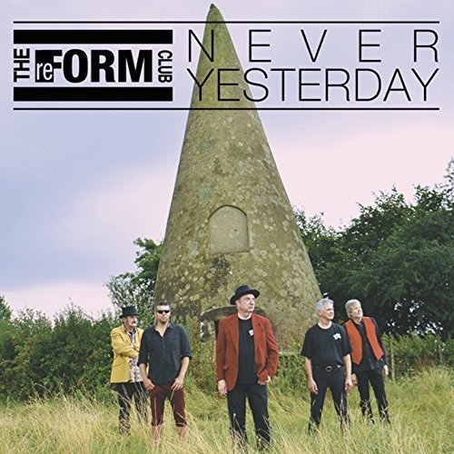 Band photo with a large stone obelisk against a blue sky.