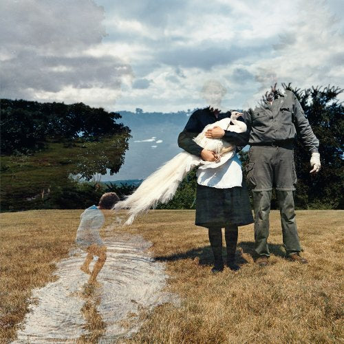 Surreal image of figures with blurred heads in a grassy field.