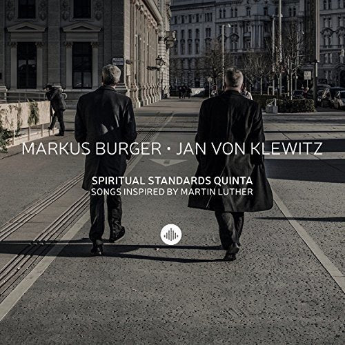 "Album cover with two men walking down a street, black and white image."