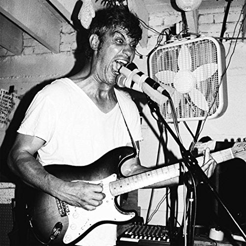 Black and white photo of a musician intensely playing electric guitar.