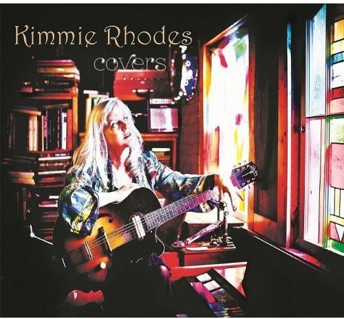 Album cover: woman with long blonde hair holding guitar, surrounded by music equipment.