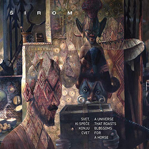 Vinyl album cover featuring a man and decorative masks in a dimly lit room.