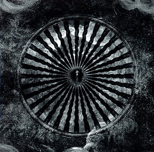 Dark album cover featuring a circular, barred window with a shadowy figure inside.