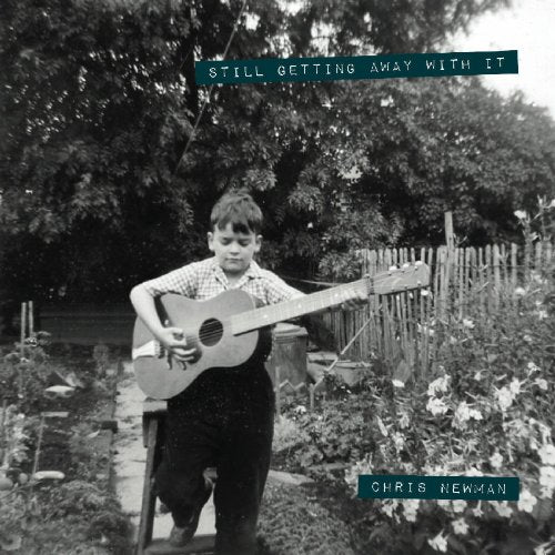 Black and white album cover with a boy holding a guitar in a garden.