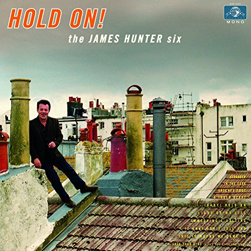 "Album cover with man on rooftop, 'HOLD ON!' in orange and white text."
