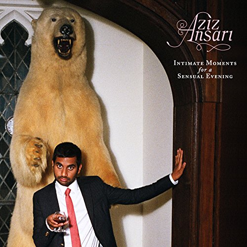 Aziz Ansari in a suit standing next to a mounted polar bear.