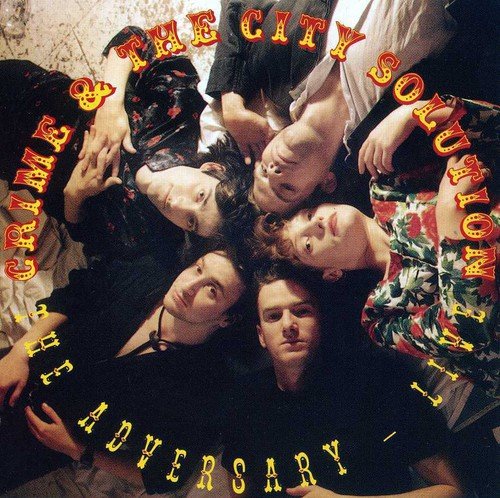 "Album cover with six men in a circle, text 'Crime & The City Solution - The Adversary'."