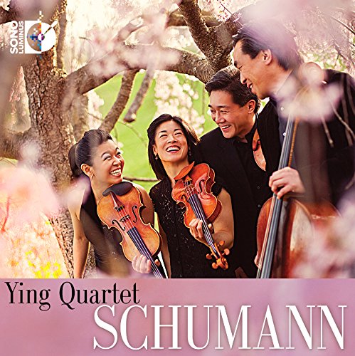 Ying Quartet performing with violins and cello under blossoming trees.