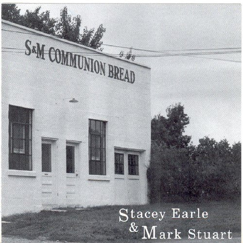 Black and white image of a white building with "S&M COMMUNION BREAD" written on it.