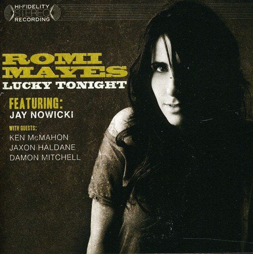 "Album cover featuring a woman with long dark hair, dark background, and gold text."
