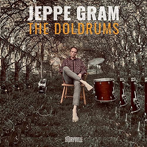 Album cover: Jeppe Gram seated amongst trees and drums.