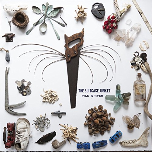"Album cover with assorted objects, including a saw, arranged around the title text."