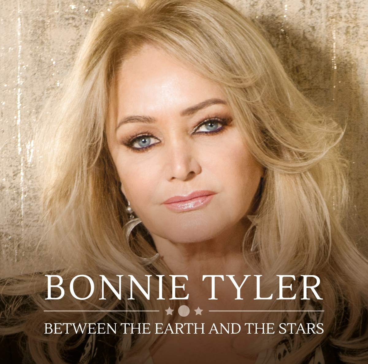 Bonnie Tyler's album cover featuring a blonde woman against a gold background.
