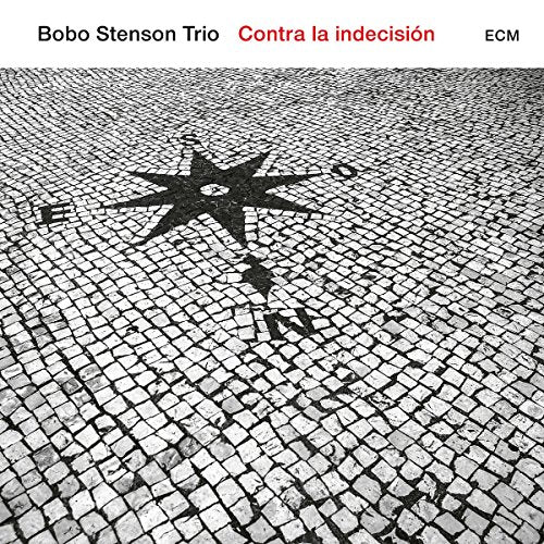 "Album cover with cobblestone image and compass rose, titled 'Contra la indecisión'."