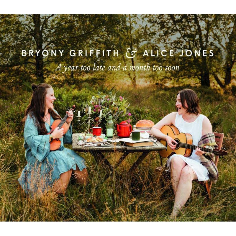 CD cover featuring two women with guitars in a grassy field.