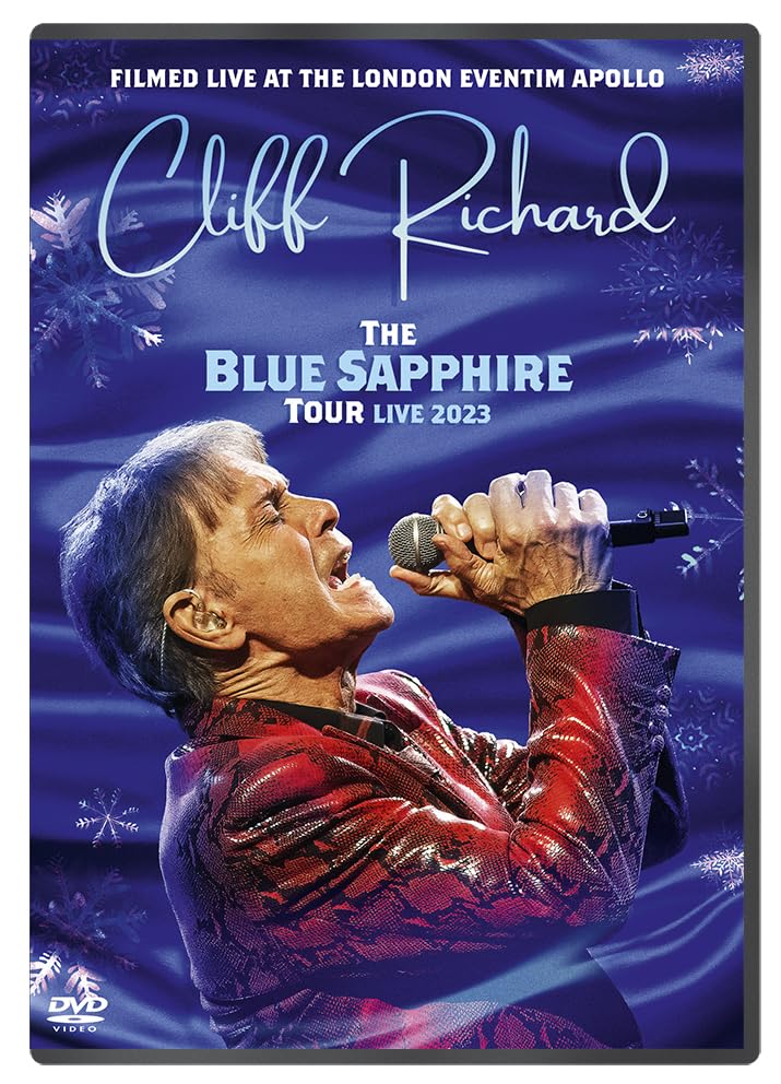 Cliff Richard singing into a microphone on a blue background with snowflake patterns.