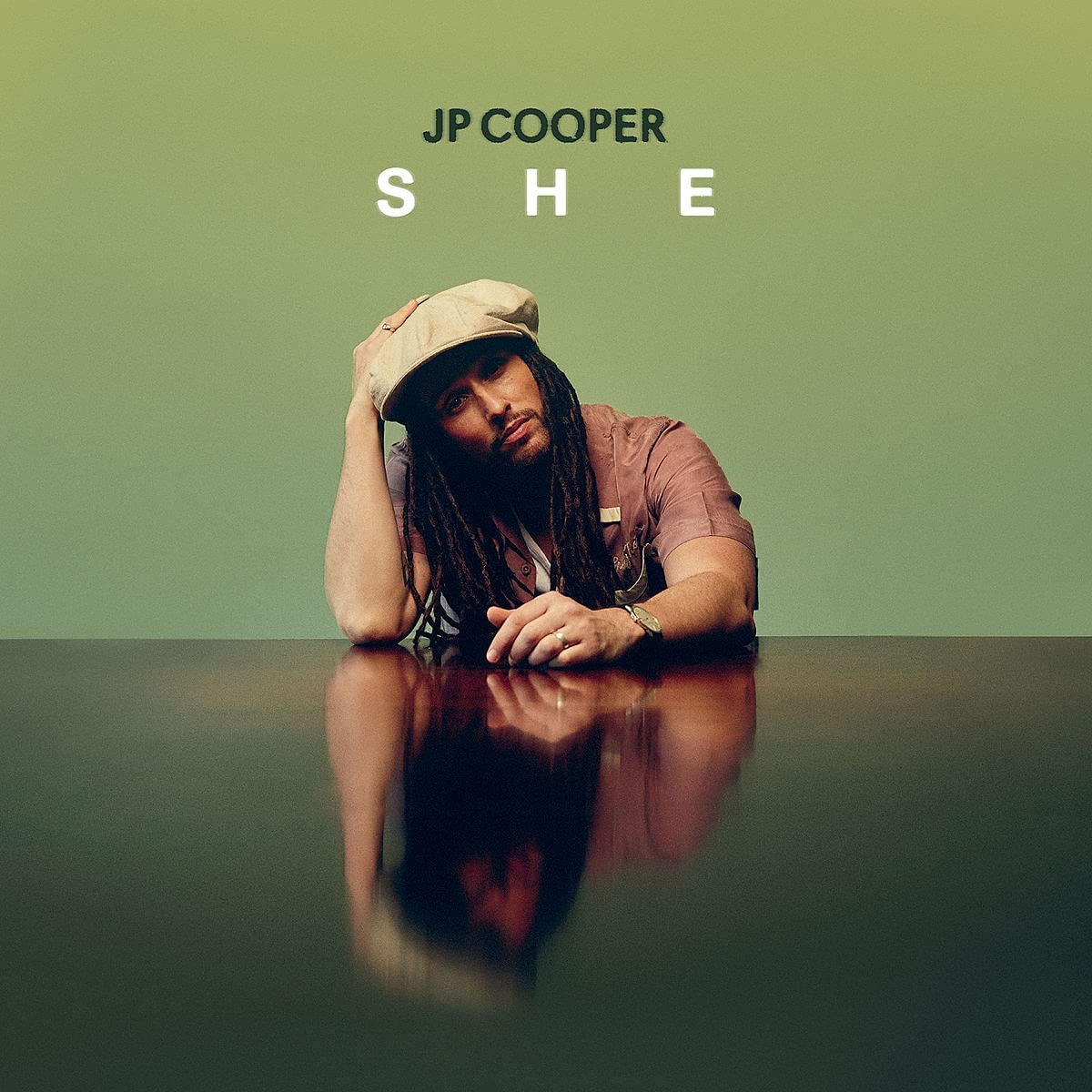 JP Cooper album cover: man in hat with dreadlocks, reflected in surface.