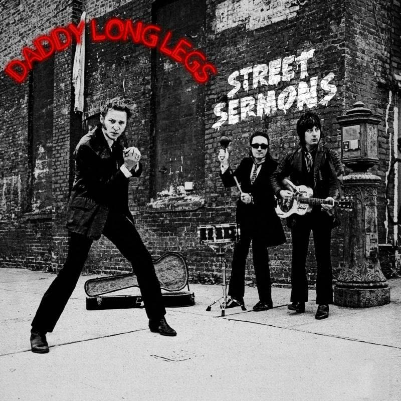 Black and white album cover featuring three musicians in suits.