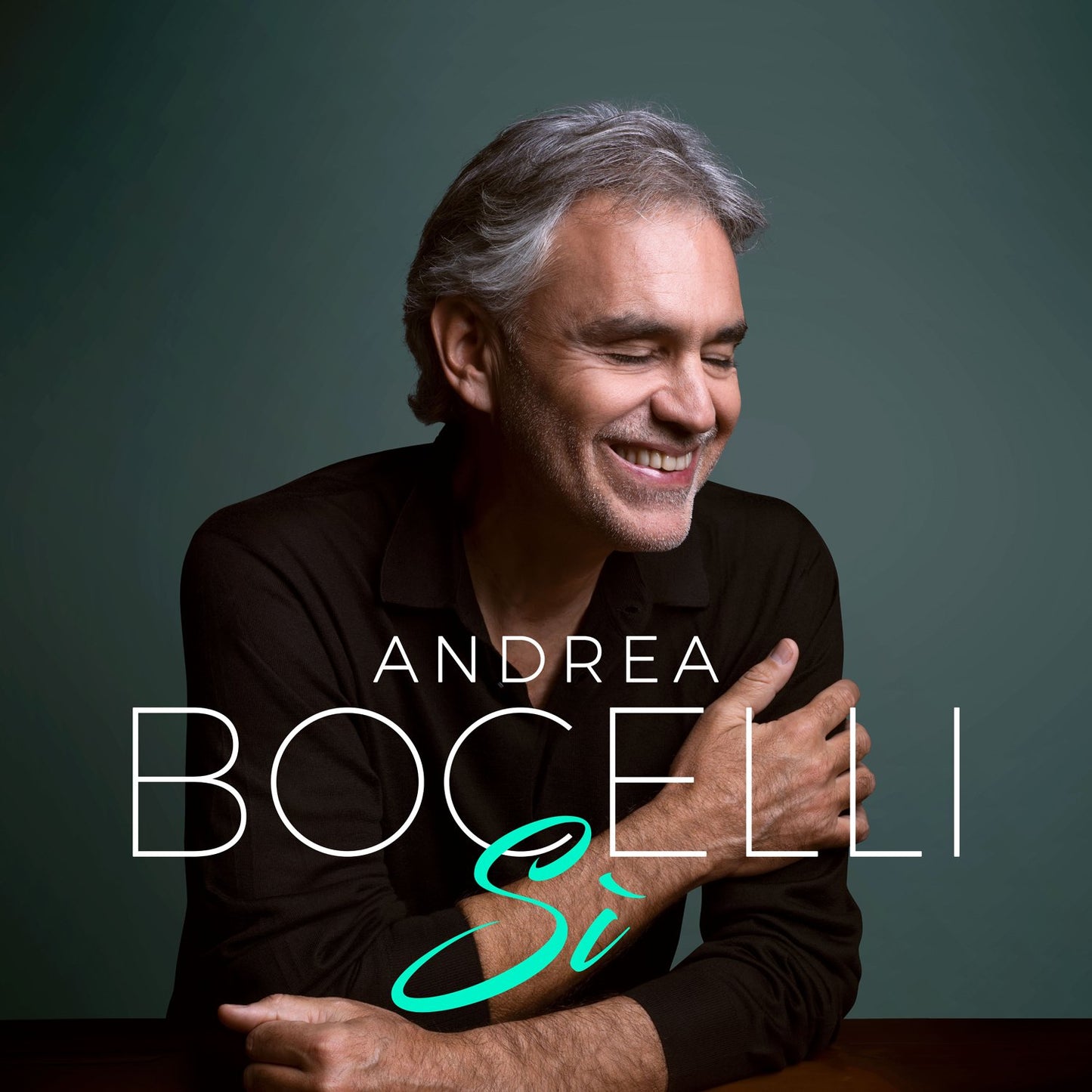 Andrea Bocelli album cover featuring a smiling man with gray hair against a dark background.