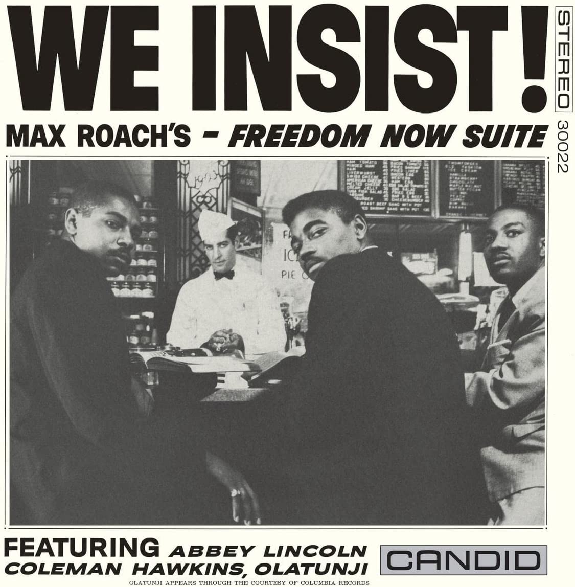 Vinyl album cover featuring a black-and-white photo of four men at a counter.