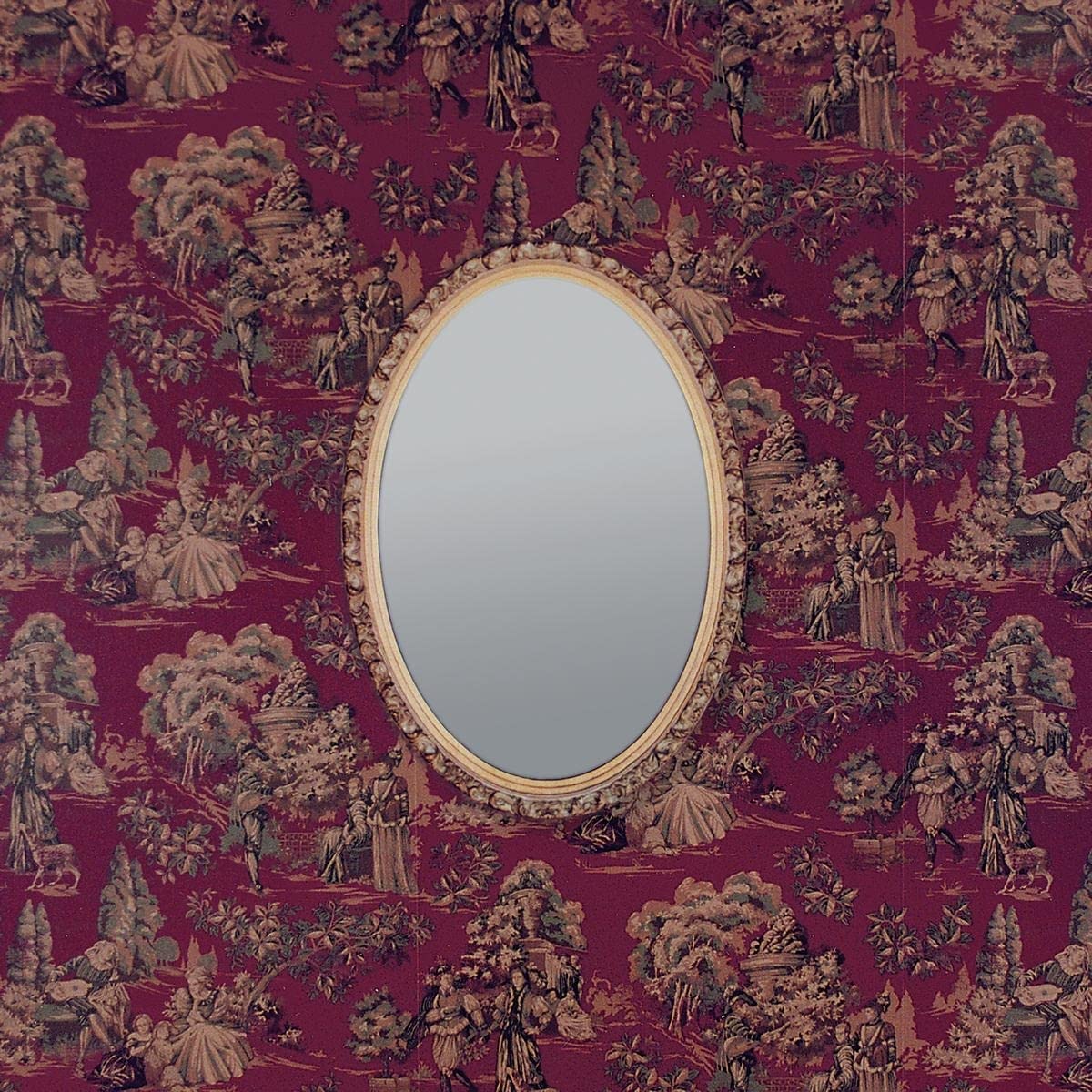 Oval mirror framed in gold against a detailed, red toile pattern.
