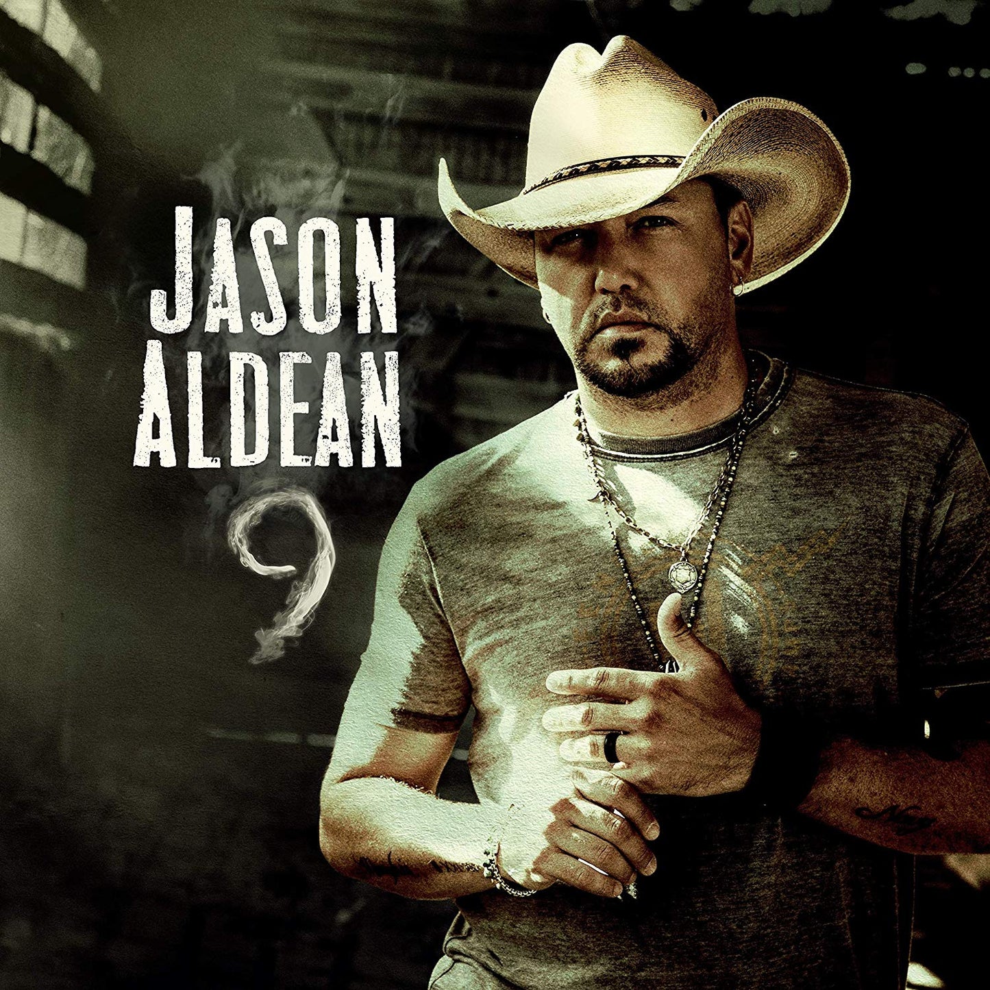 "Jason Aldean album cover featuring the artist in a cowboy hat, smoking."