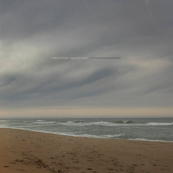 CD cover: beach scene with cloudy sky and band/album title.