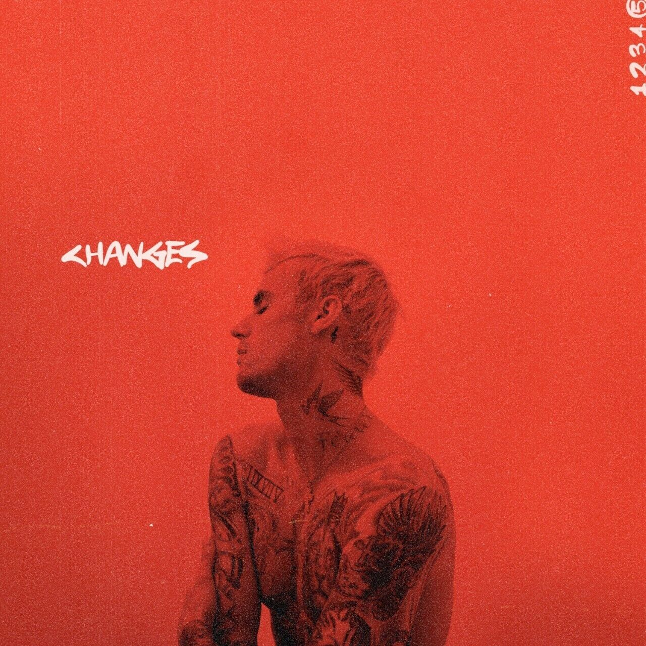 "Album cover with Justin Bieber, tattoos visible, against a red background, 'CHANGES' written."