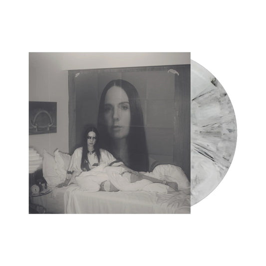 Black and white photo of a woman in a bedroom, with a ghostly overlay.