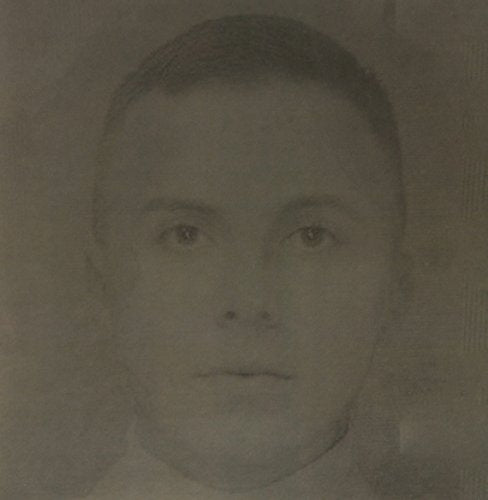 A sepia-toned, close-up portrait of a young person with short hair facing forward.
